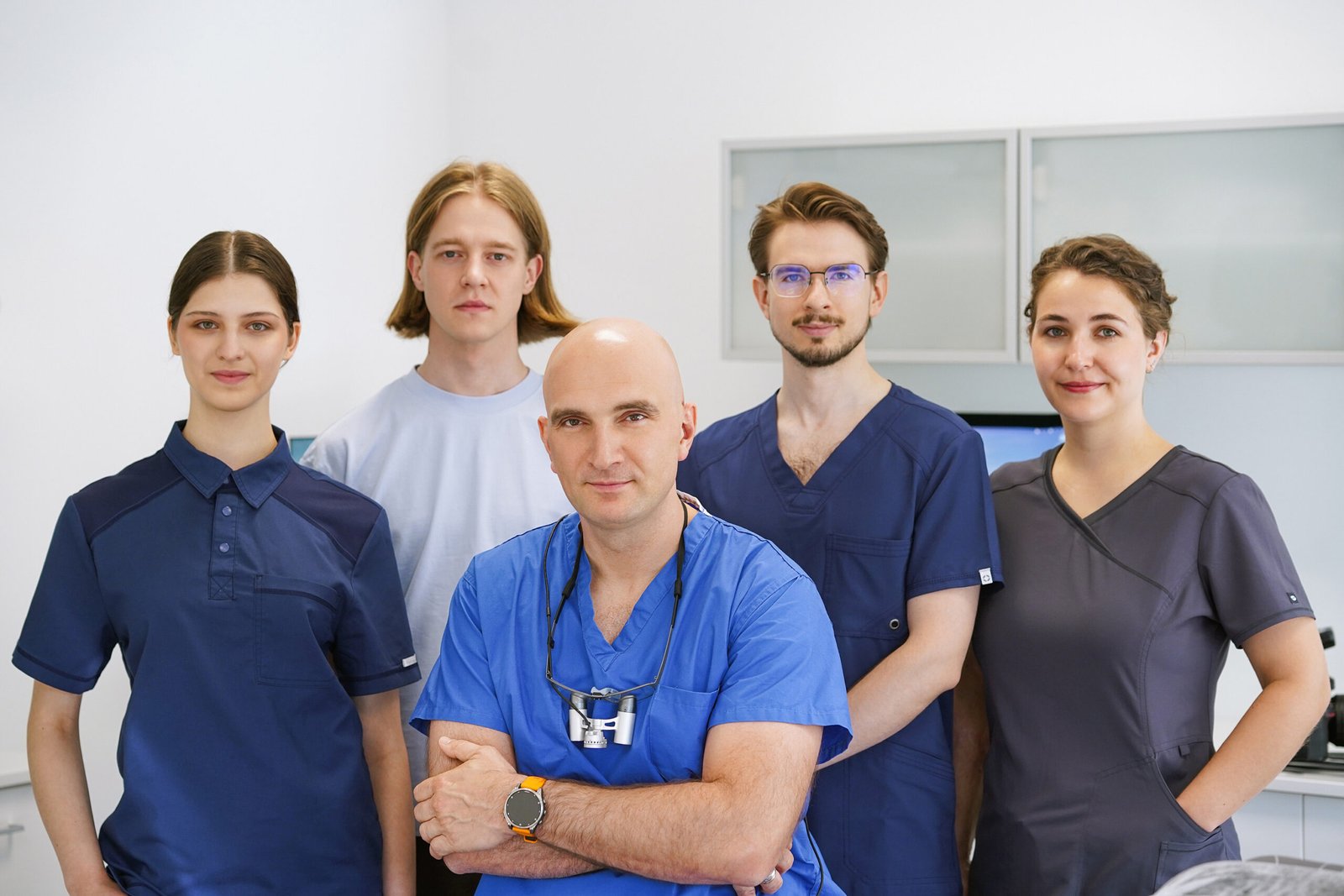 Das fünfköpfige Team der GO Privatpraxis Wuppertal in Berufskleidung im Behandlungszimmer